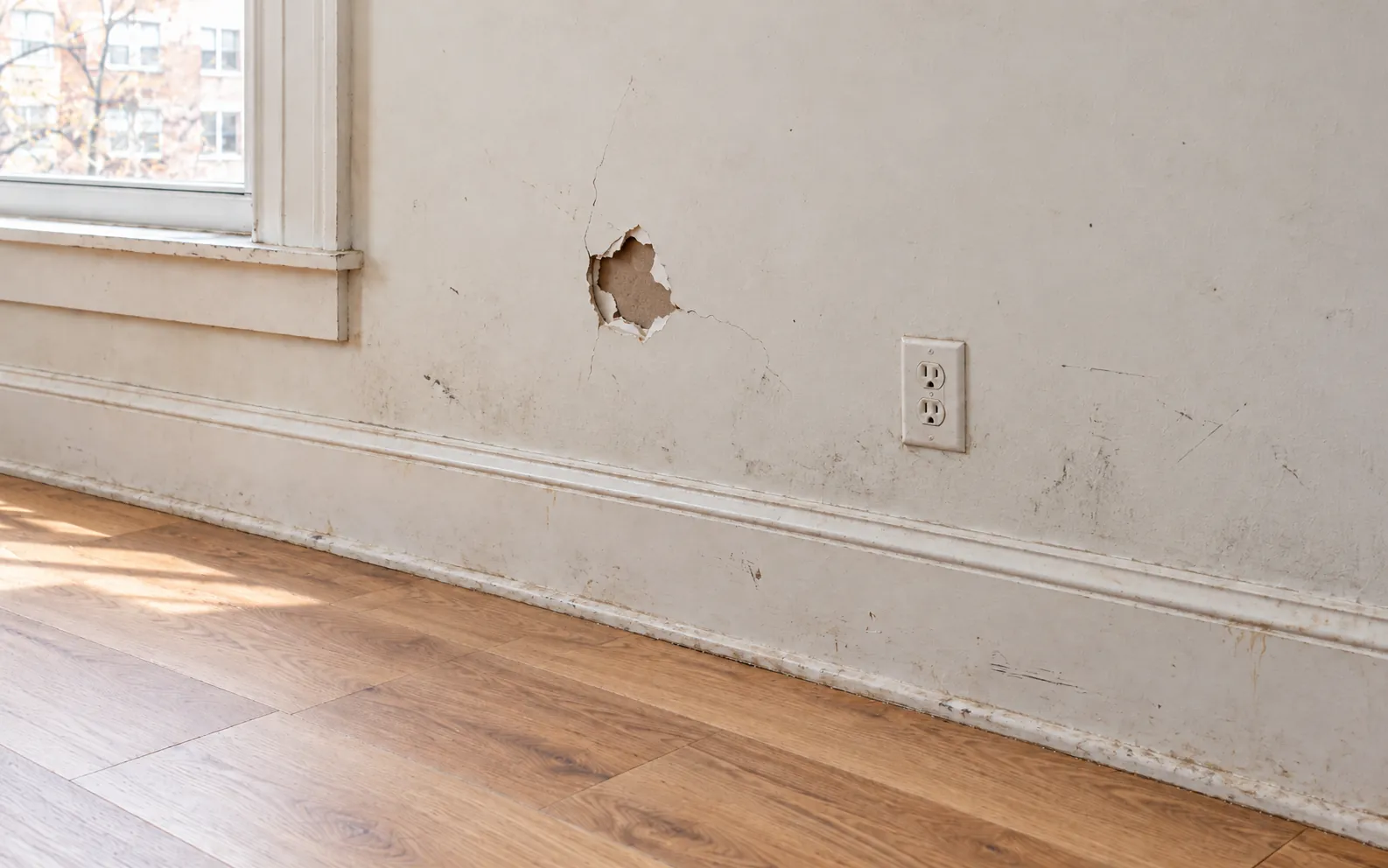 Before: a wall with an impact hole and cracks