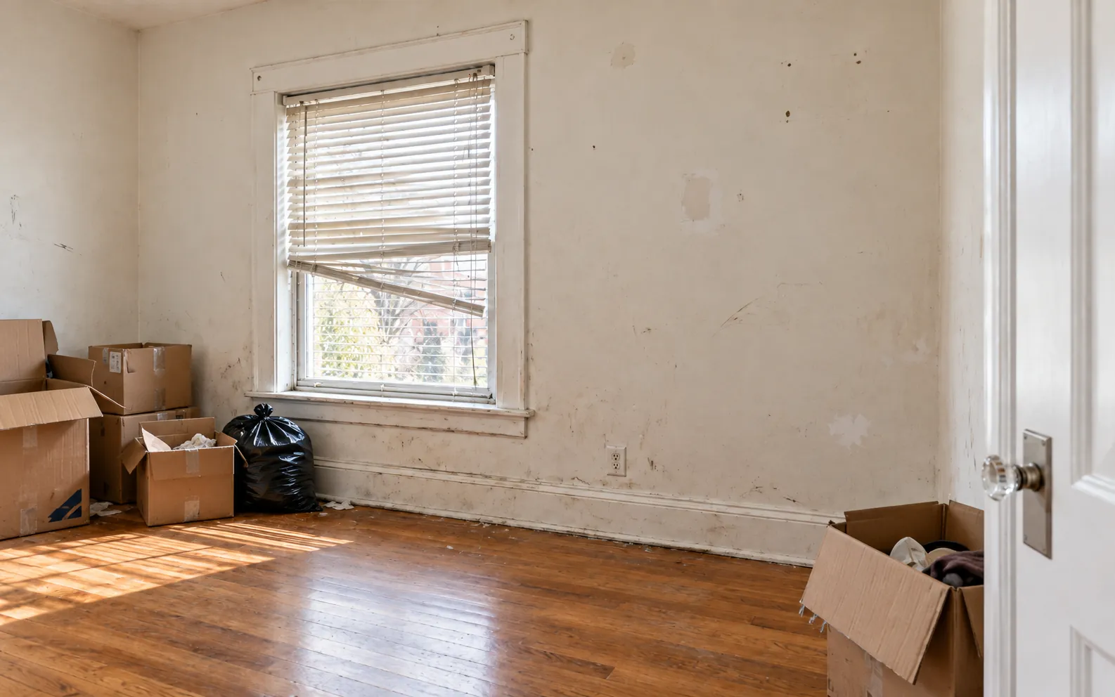 Before: a room in move-out condition with boxes and scuffed walls